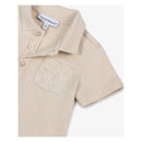 Beige short sleeve polo shirt for baby boys featuring a textured logo pocket and three button closure.