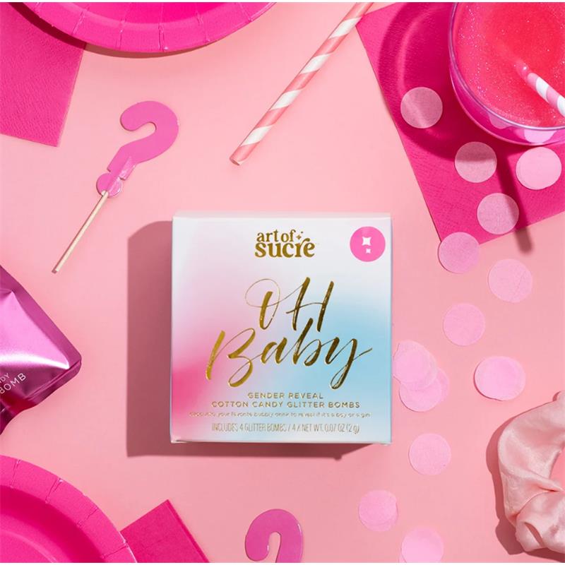 Gender reveal cotton candy glitter bombs by Art of Sucre, featuring pink packaging and decorative elements on a pink background.