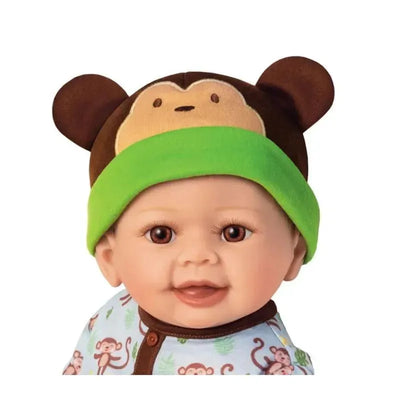 Lifelike baby doll named Lucas, wearing a monkey-themed hat and a patterned onesie with monkeys.