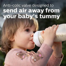 Toddler drinking from an Avent 11oz baby bottle, featuring an anti-colic valve to reduce air intake.