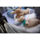Baby sleeping in a stroller, holding a brown plush monkey toy and a teal pacifier.