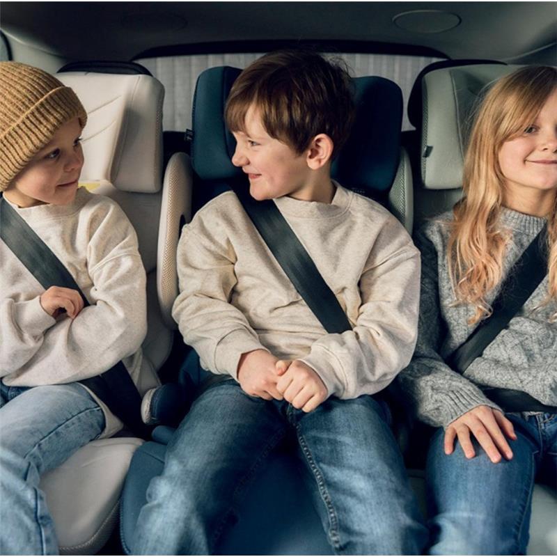 Three children wearing seatbelts sit in the back seat of a car, each positioned in high back booster seats.