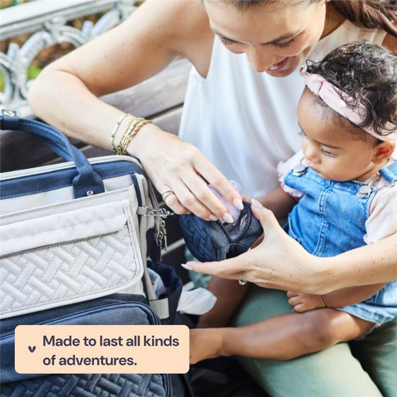 Diaper bag backpack in dark gray is being used by a mom while caring for her baby, showcasing a modern design.