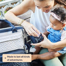 Diaper bag backpack in dark gray is being used by a mom while caring for her baby, showcasing a modern design.