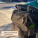 Black BabbleRoo diaper bag backpack with multiple pockets, attached to a stroller, featuring a green item visible inside.