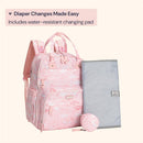 Pink Birdy diaper bag backpack with water-resistant changing pad and matching pouch, designed for easy diaper changes.