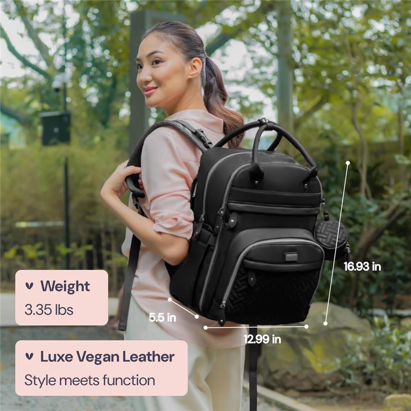 Black leather diaper bag backpack worn by a woman outdoors, featuring ergonomic straps and visible measurements.