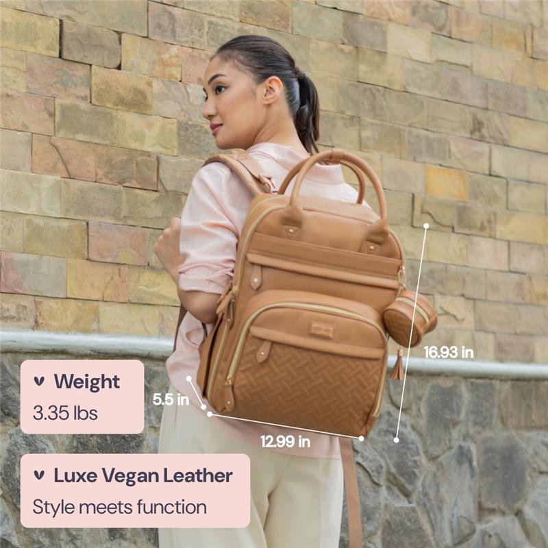 Light brown Babbleroo diaper bag made of vegan leather, displayed by a woman against a stone wall, highlighting its dimensions and key features.