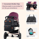 Black BabbleRoo Travel Essentials Baby Bag with changing pad, attached to a stroller, featuring clips for easy attachment.