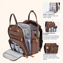 Brown travel essentials baby bag with changing pad, featuring multiple pockets for diapers and bottles.