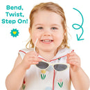 Children’s cat-eye shaped UV sunglasses in white held by a smiling toddler wearing a floral dress, with playful text.