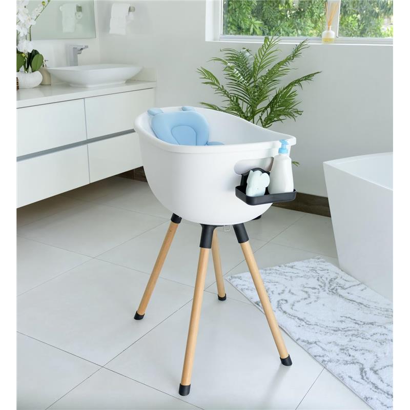 Bath support pillow in sky blue positioned in a stylish bath support stand with accessories in a modern bathroom.