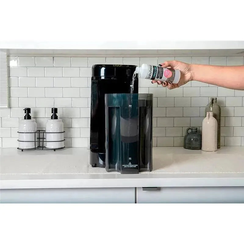 Universal descaling solution being poured into a Baby Brezza appliance with a modern kitchen background.