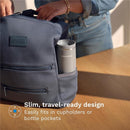 Baby Brezza Super Fast Portable Bottle Warmer in a gray backpack pocket, highlighting its travel-friendly design.