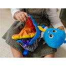 Sensory Plush Octopus toy in bright colors, held by a child in a striped dress, showcasing its textured fabric.