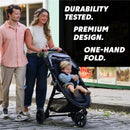 Baby Jogger City Mini GT3 stroller in Sierra Sand, with a child smiling in the seat. A couple walks beside it, showcasing features like durability and easy folding.