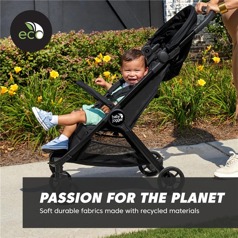 Baby Jogger City Tour 2 Travel Stroller with a smiling child seated inside, surrounded by blooming flowers, showcasing eco-friendly features.