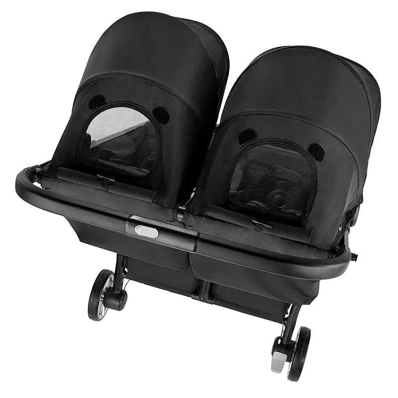 Double stroller in pitch black color, featuring two canopies, mesh windows, and a compact design for easy maneuverability.