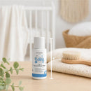 Travel size 2oz Baby Jolie 2-in-1 Hair and Body Wash with a white bottle displayed on a wooden surface next to a wooden brush and fabric.