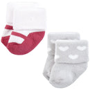 Twelve pairs of baby socks in pink and black designs, featuring striped and heart patterns, with cuffed tops.