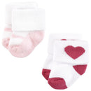 Twelve pairs of baby socks in pink and black, featuring a pattern with a heart design on one pair.