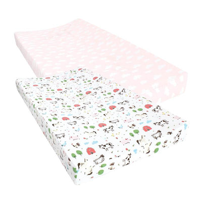 Two cotton changing pad covers featuring a pink cloud pattern and a farm animal print with cows, trees, and barns.