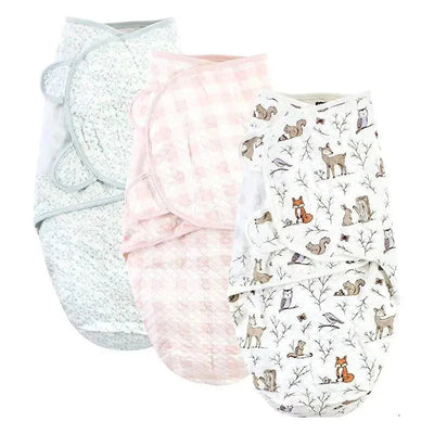 Three quilted cotton swaddle wraps in pastel colors featuring floral, gingham, and enchanted forest animal patterns.