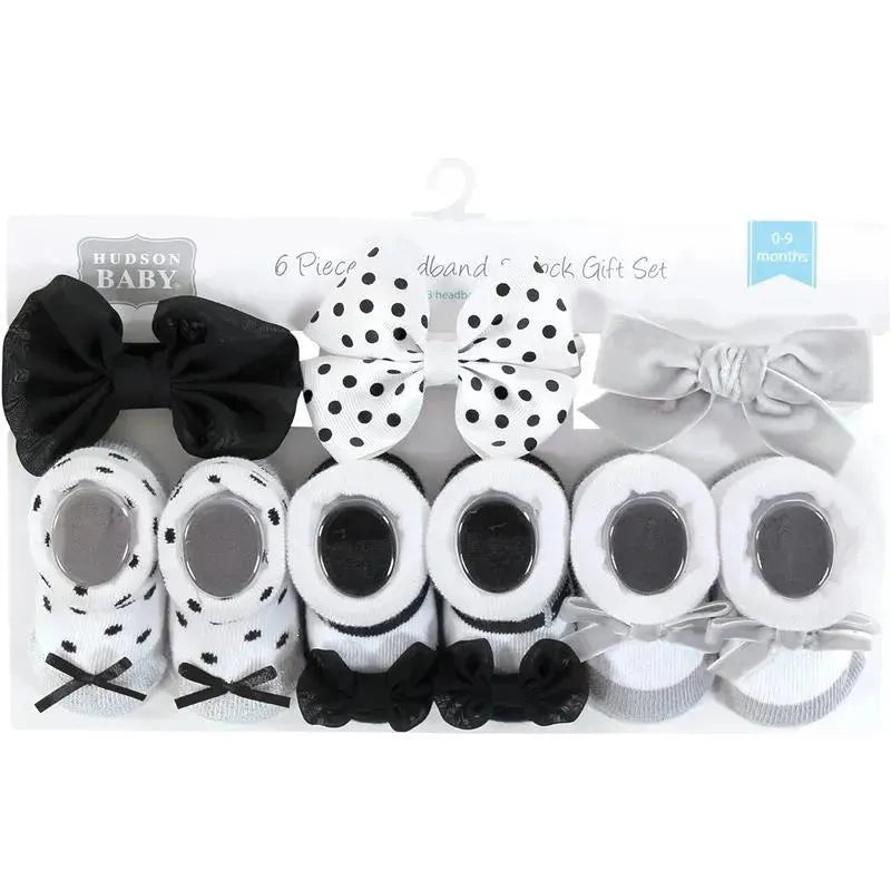 Six-piece gift set featuring black and silver headbands and socks with various designs, suitable for baby girls.