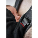 Black cover for Babybjorn baby carrier, featuring a safety buckle and a baby sleeping peacefully inside.