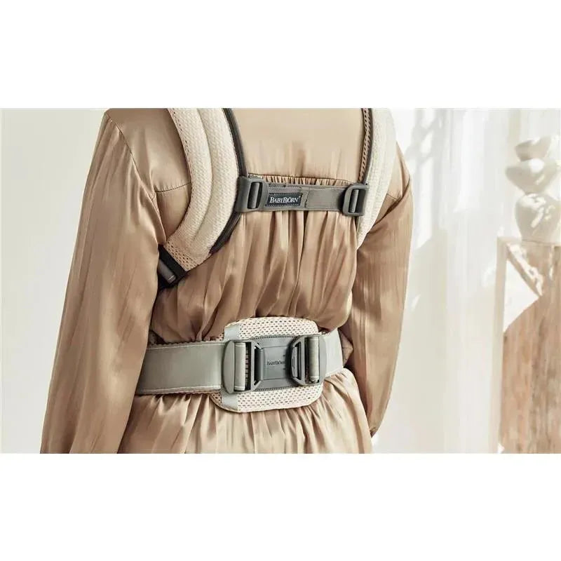 BabyBjorn Baby Carrier Harmony in cream 3D mesh, showcasing adjustable straps and a padded waist belt from a back view.