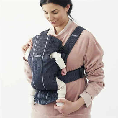 Babybjorn Baby Carrier Mini in anthracite, showcasing a woman holding a baby close to her chest, both appearing relaxed.
