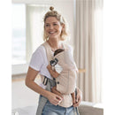 Mother smiling while holding a baby in a BabyBjörn Carrier Mini, 3D Mesh in Pearly Pink, with soft interiors and ergonomic design.