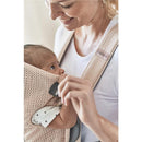 BabyBjörn Baby Carrier Mini in Pearly Pink, with a mother holding a baby securely in the mesh fabric, both smiling.