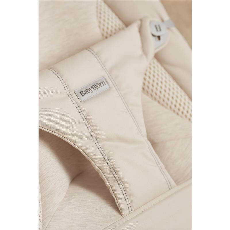 Light beige BabyBjörn Bouncer Balance Soft with a padded seat and adjustable harness for infants, featuring a mesh design.