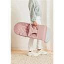 A person holding the Babybjorn Bouncer Bliss in Dusty Pink with a textured petal quilt design.