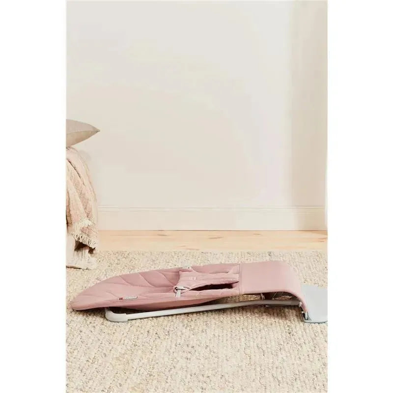 Babybjorn Bouncer Bliss in Dusty Pink, featuring a quilted petal design, sits on a textured rug.
