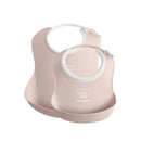 Two Babybjorn feeding bibs in powder pink, featuring a soft design and a bear logo, ideal for mealtime use.
