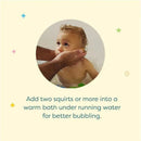 Child enjoying a bath with hands applying Babyganics bubble bath, instructions for use displayed below.