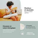 Mother feeding a baby with the Babymoov B.Love 2-in-1 organic pregnancy pillow on a couch, highlighting comfort and adjustable features.