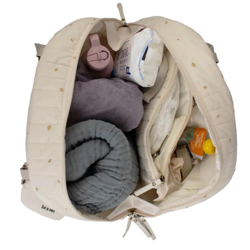 Bbluv Doudoune Changing Bag opened to reveal interior items including soft towels, wipes, and baby essentials.