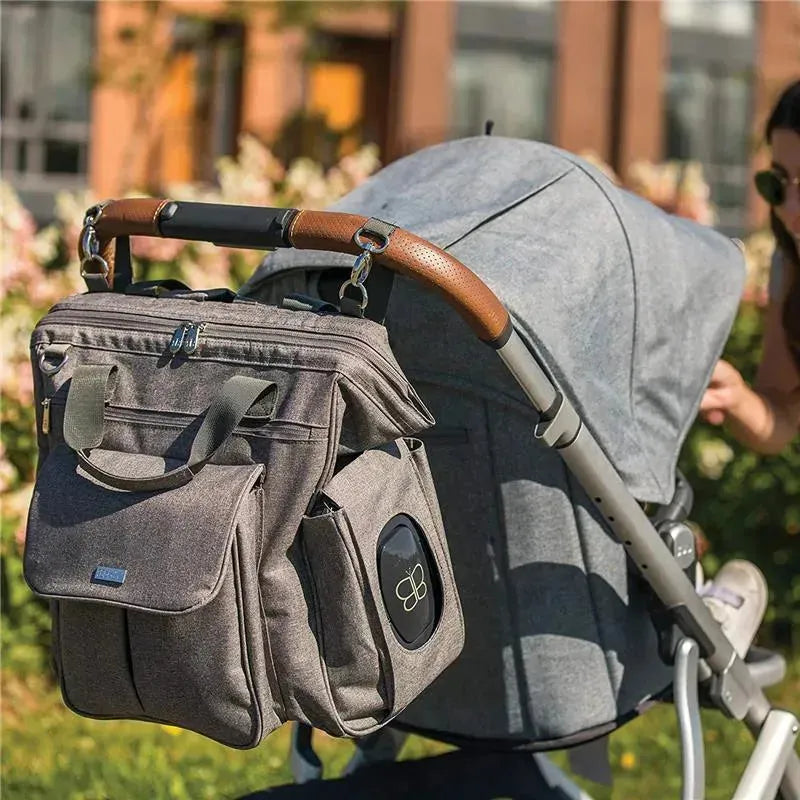 Charcoal Bbluv Metrö Complete Backpack Diaper Bag attached to a stroller, featuring multiple pockets and a sleek design.