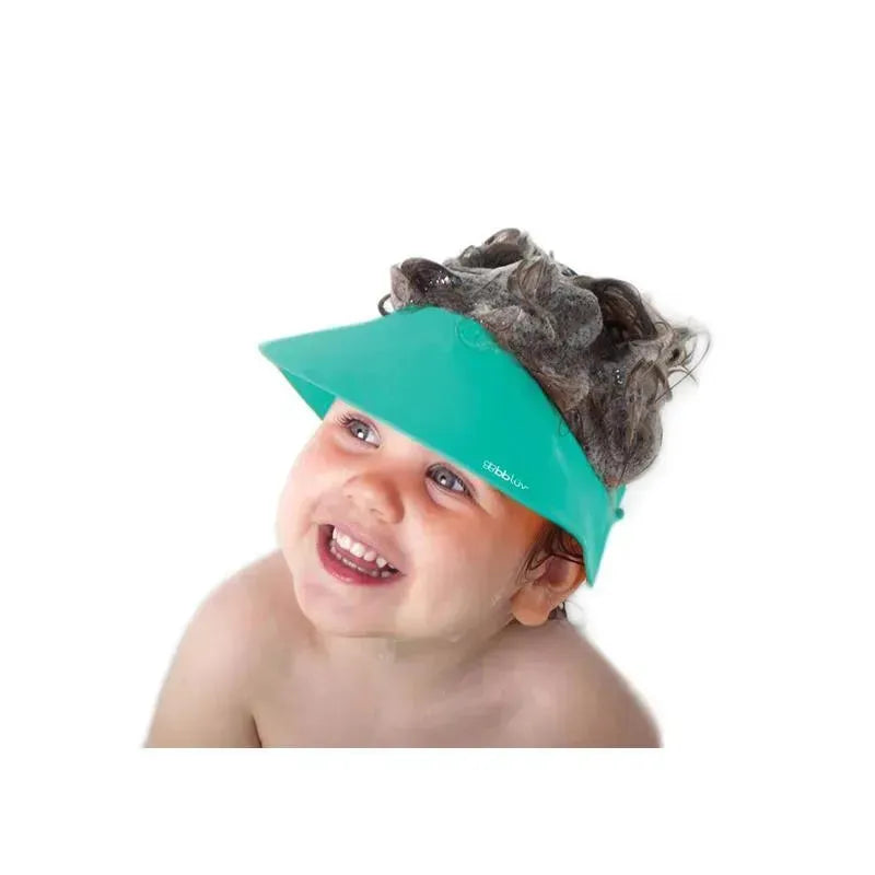 Bbluv Silicone Shampoo Repellent Cap in aqua worn by a smiling child, protecting eyes from shampoo while bathing.