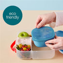 Silicone lunch tub in berry color with sections for food, featuring green apple, yogurt, and mixed salad. Eco-friendly design.