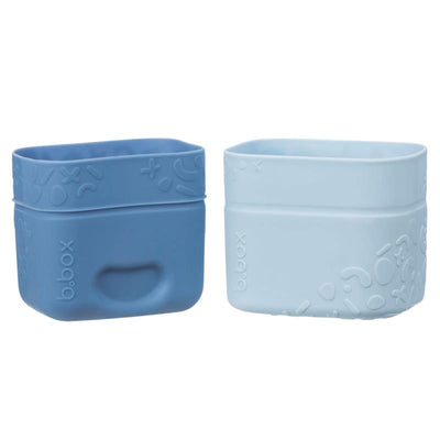 Silicone snack cups in ocean-themed colors, one light blue and one darker blue, featuring playful textured designs.