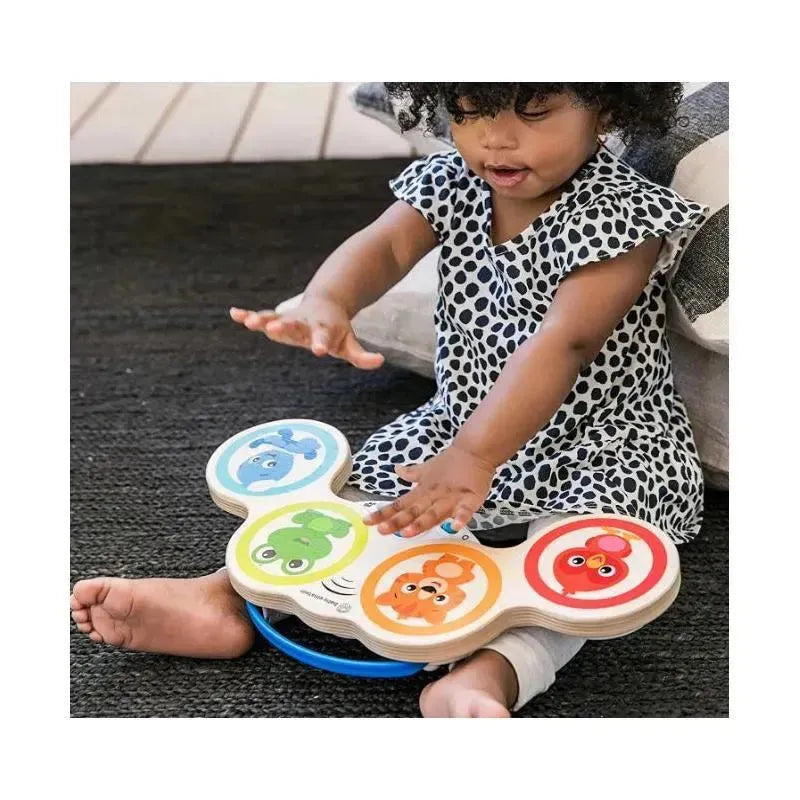 Child playing with the Be Hape Magic Touch Drum, featuring colorful animal graphics on the drum pads.