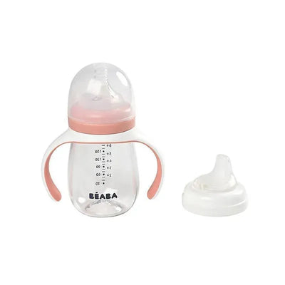 Beaba 2-in-1 bottle to sippy learning cup in rose, featuring a transparent body, handle, and removable silicone spout.