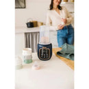 Beaba 5-in-1 Multi Milk Baby Bottle & Food Warmer in Midnight color, with visible control panel, surrounded by baby bottles.