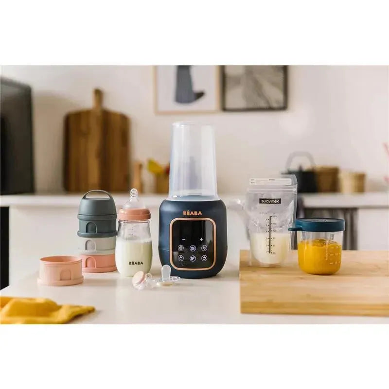 5-in-1 Beaba Multi Milk Baby Bottle & Food Warmer in Midnight color, with various baby bottles and food containers displayed on a kitchen counter.