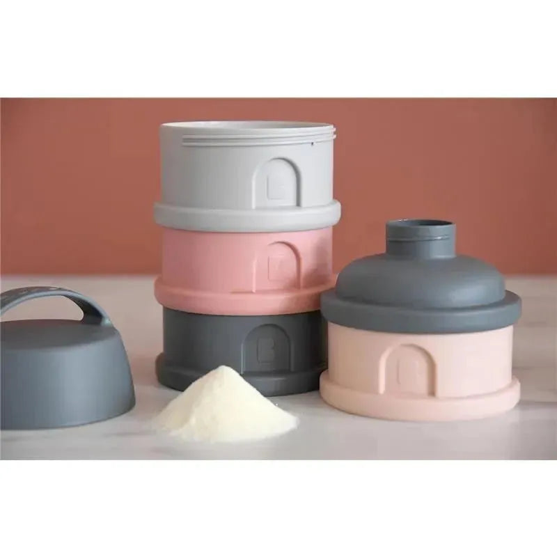 Beaba formula and snack container set in rose, including stacked grey and pink containers, with a small pile of powder.