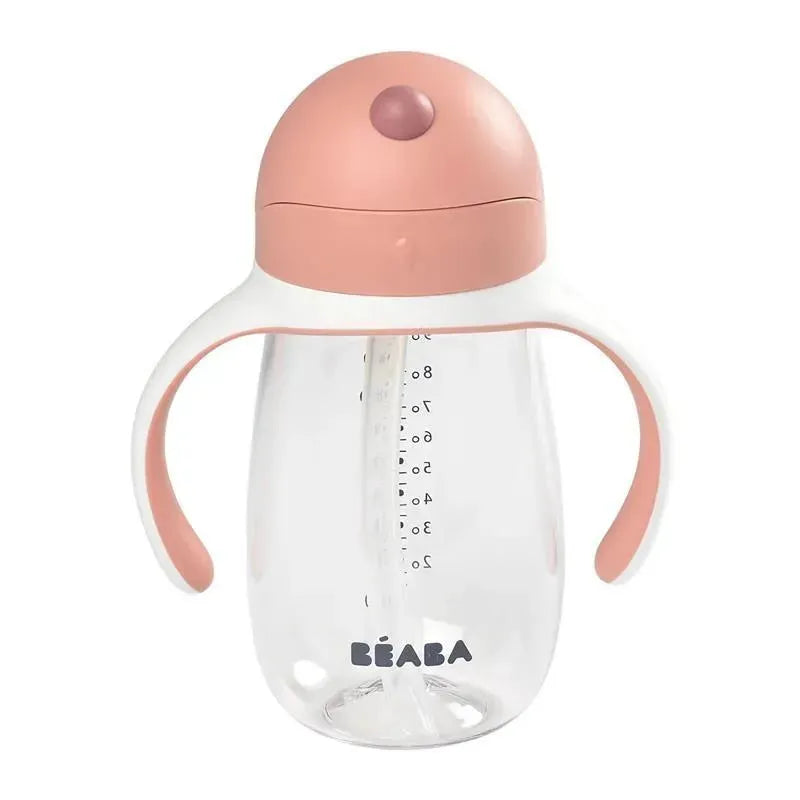 Beaba straw sippy cup in rose color with clear body, measurement markings, and ergonomic handles.